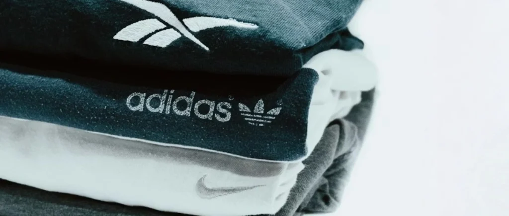 Pulls empilés pour représenter l'univers mode. De haut en bas : pull Reebok, pull Adidas, pull Nike.