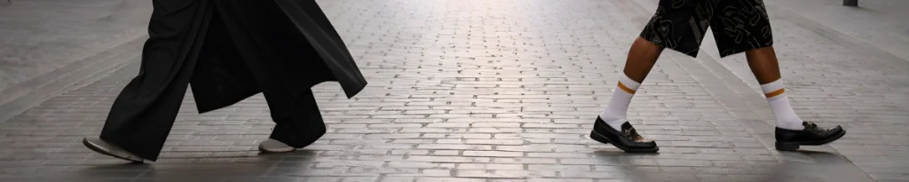 Un homme et une femme qui portent un outfit et qui marche dans directions opposées.