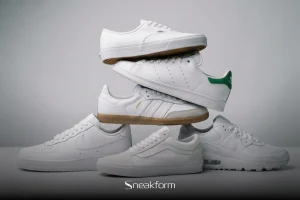 Six modèles de sneakers blanches empilés, Vans Authentic, Adidas Stan Smith, Adidas Samba à semelle gomme, Nike Air Force 1, Vans Old Skool et Nike Air Max 90.