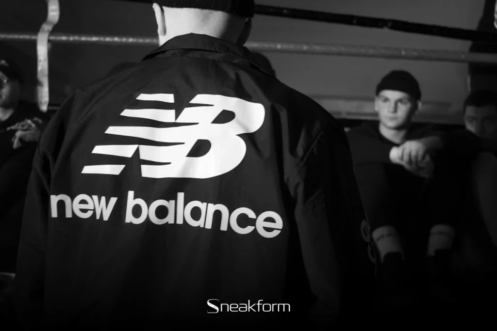 Logo New Balance sur veste bomber noire, univers streetwear et lifestyle New Balance.