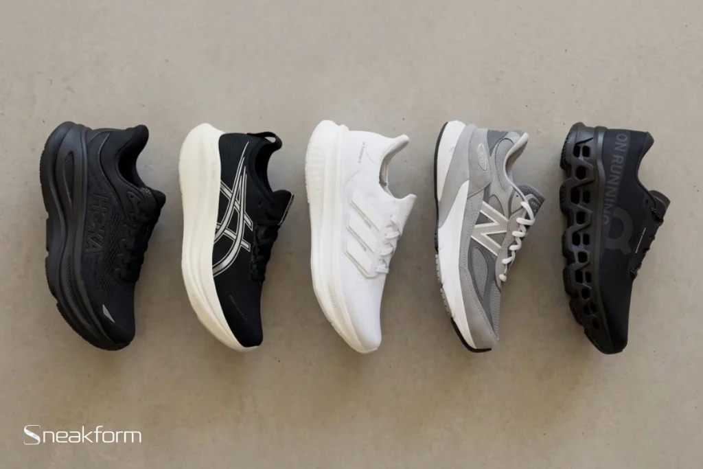 Sélection des baskets confortables 2025 en flat lay : Hoka Bondi 9, Asics Gel-Nimbus 27, Adidas Ultraboost 5, New Balance 990v6 et On Cloudmonster 3.