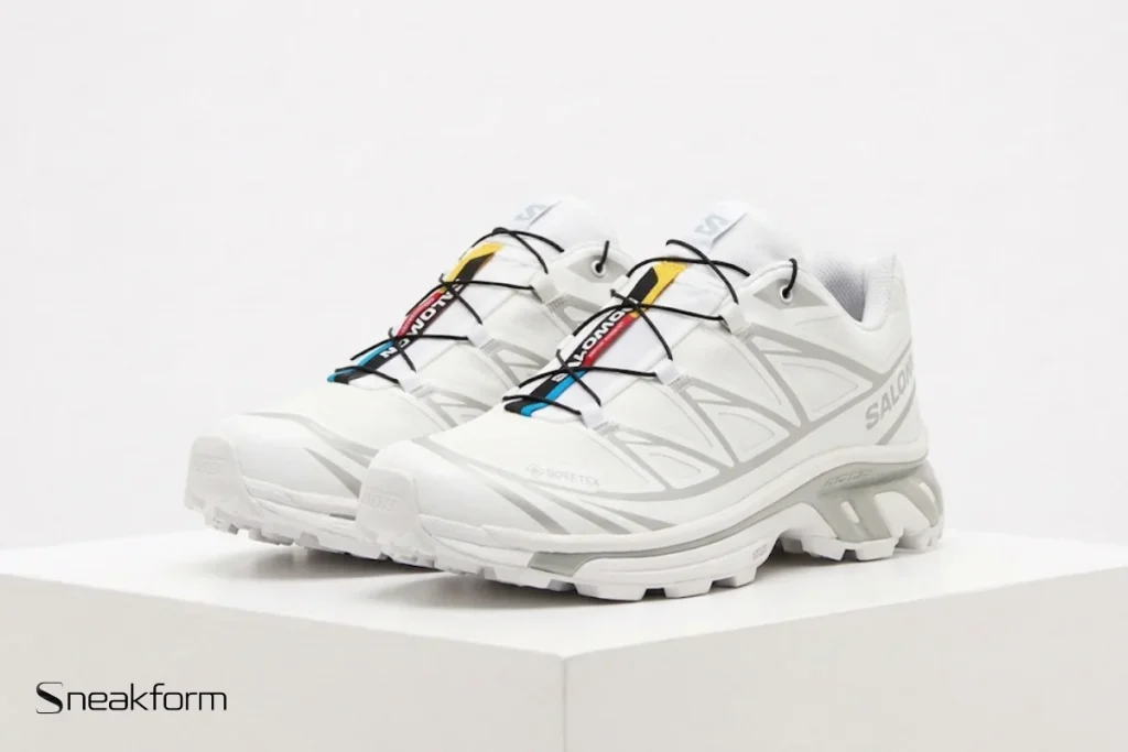 Sneakers tendance 2026, Salomon XT-6 blanche avec laçage rapide et semelle crantée.