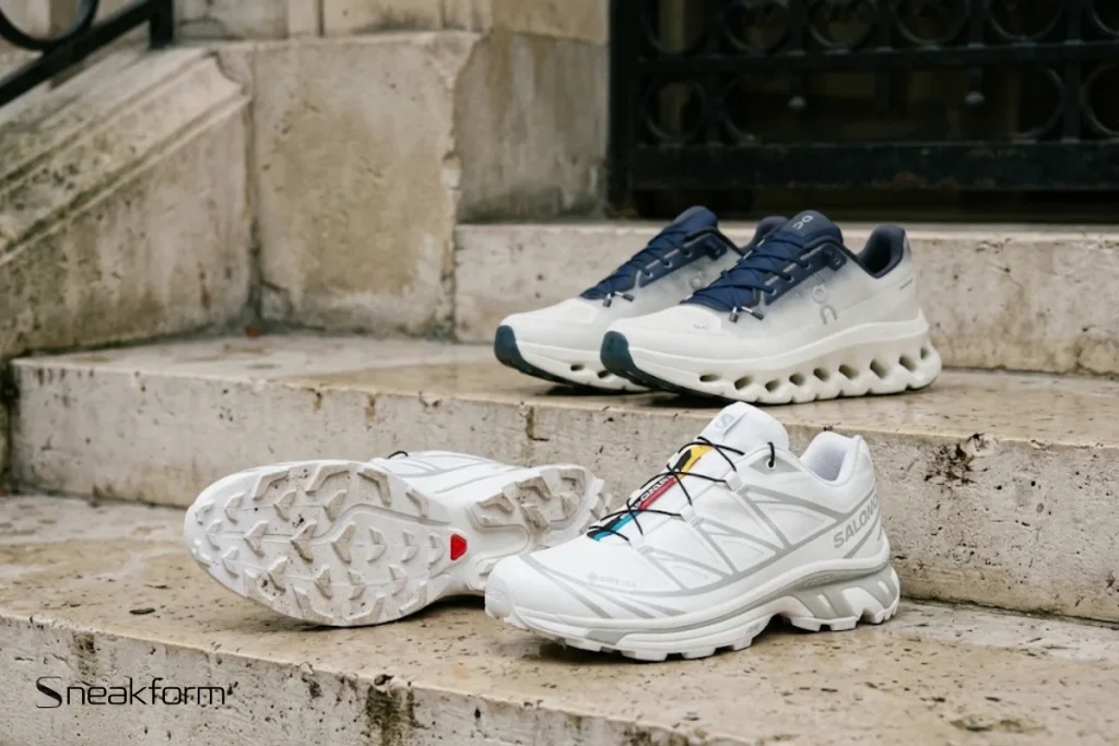 Sneakers tendance 2026, Salomon XT-6 et On Cloudtilt posées sur les marches en pierre d'un immeuble parisien, silhouettes techniques.